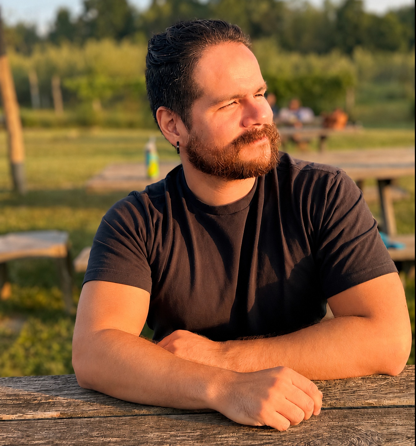 Portrait of Edvard Aviles-Meza seated outdoors in evening light